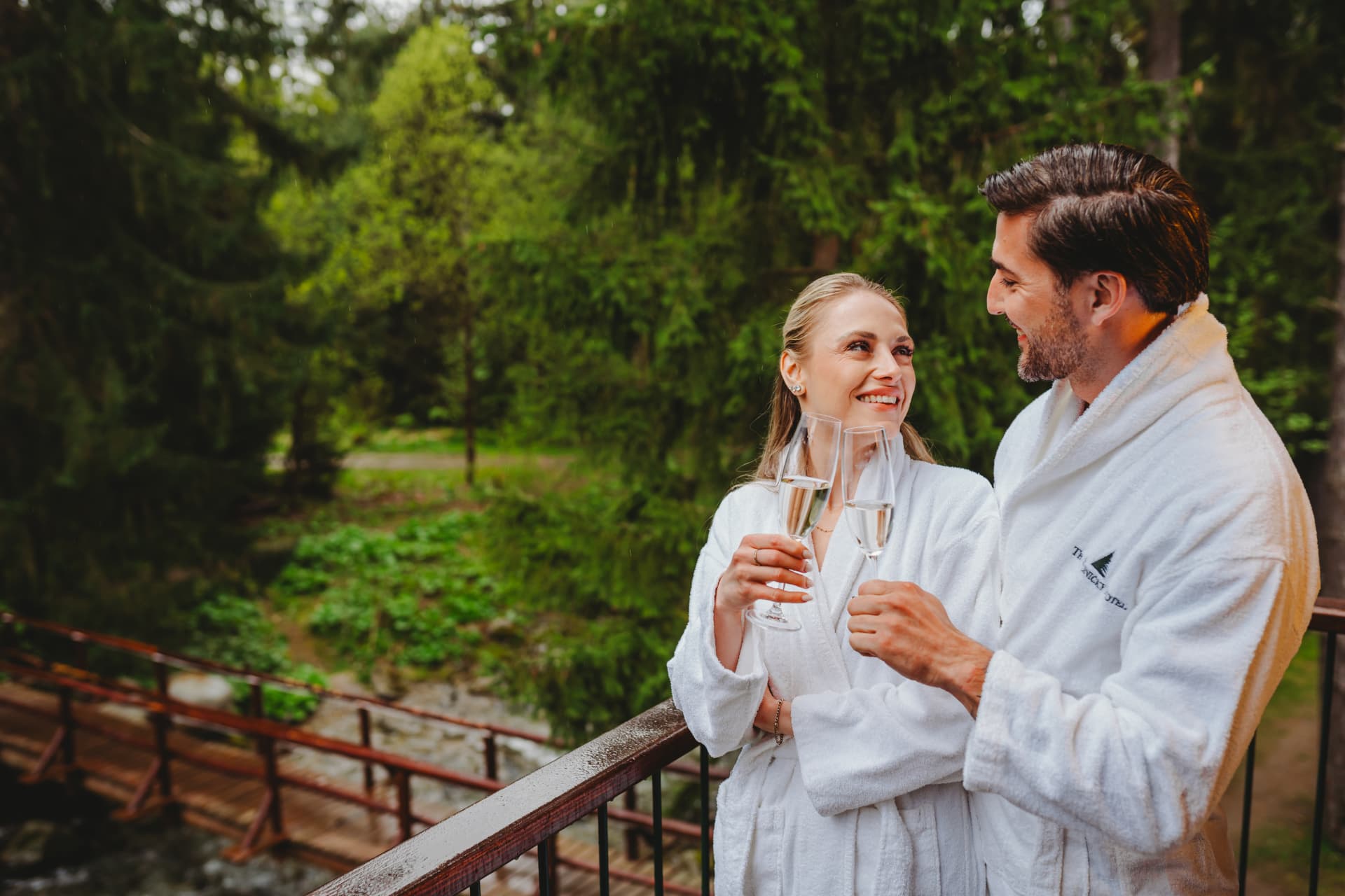 Guests in bathrobes on the terrace overlooking the forest