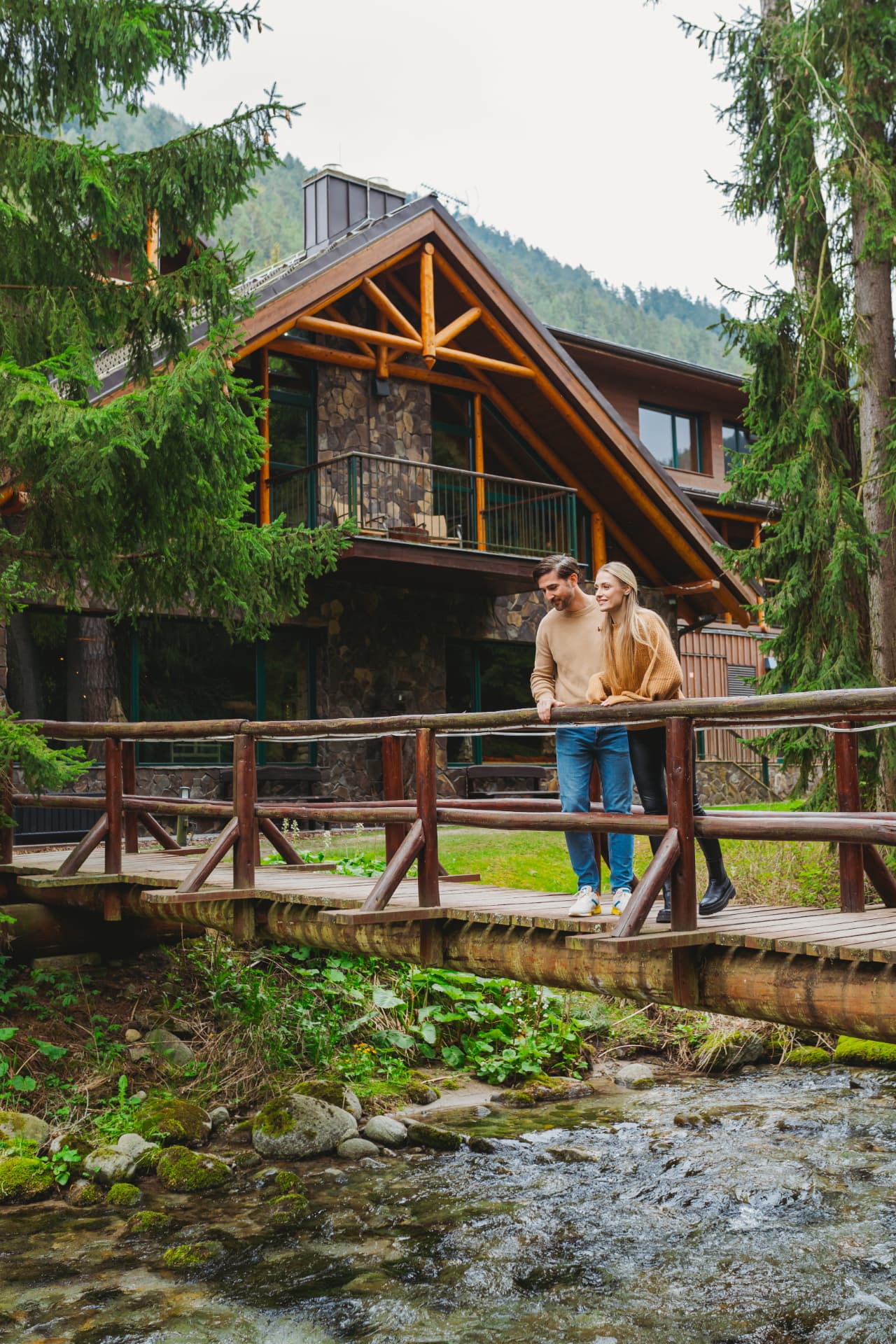 Wooden bridge over the mountain stream at Hotel Tri Studničky